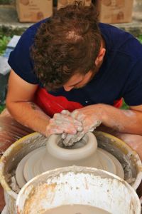 Lou Lourdeau's pottery pics, potter spinning clay